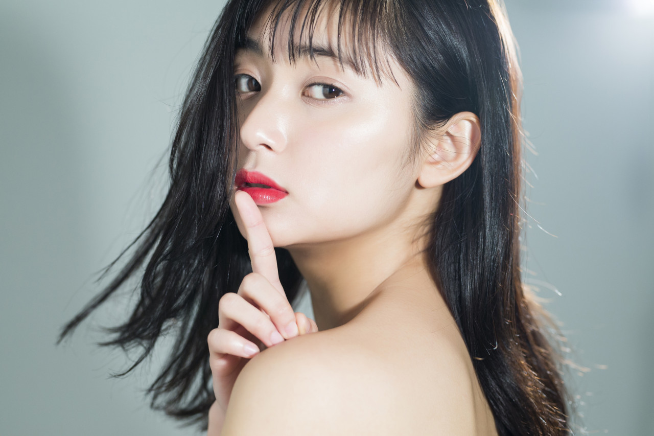 人差し指で口を隠す女性